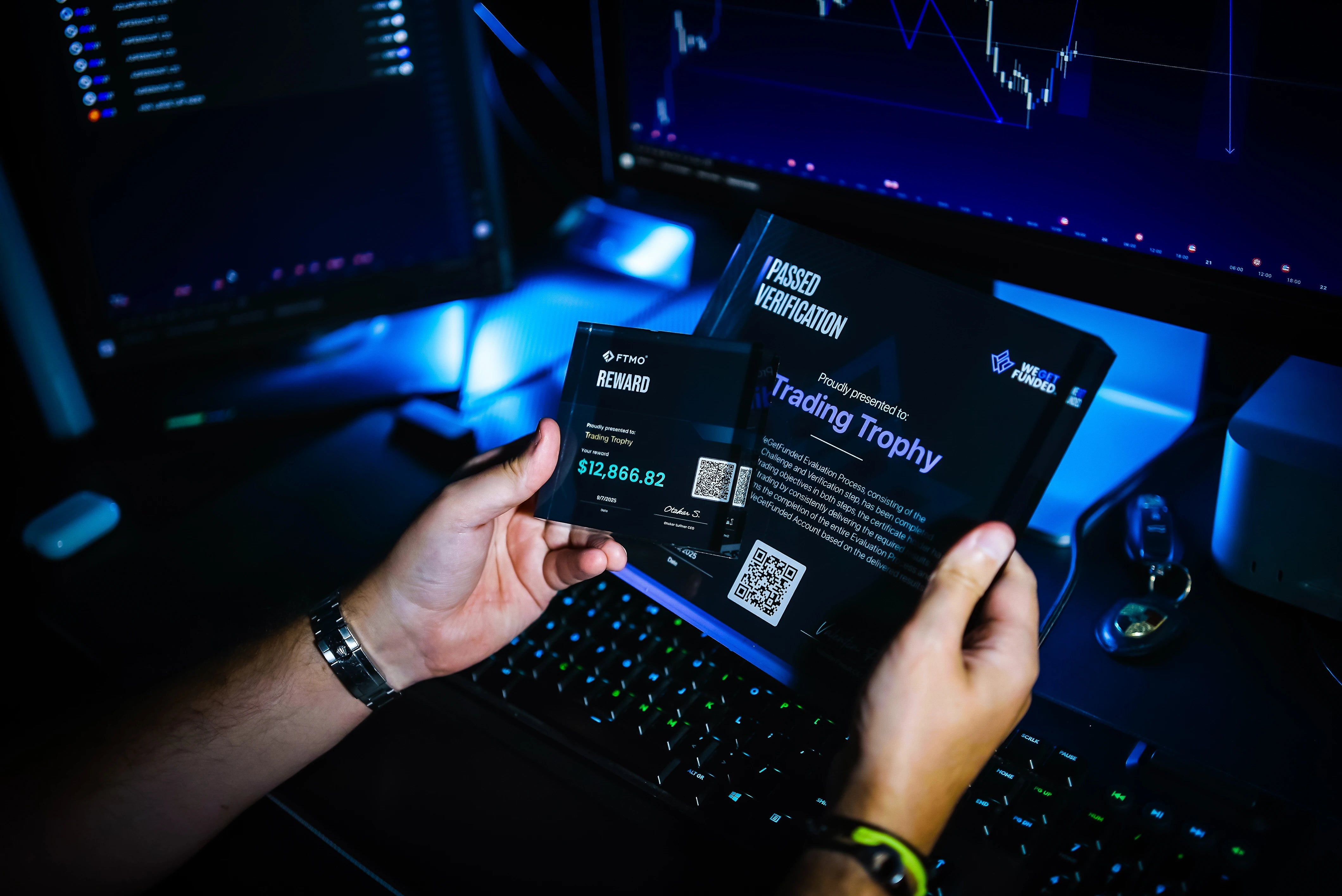 trader holds two trading trophies in his hands
