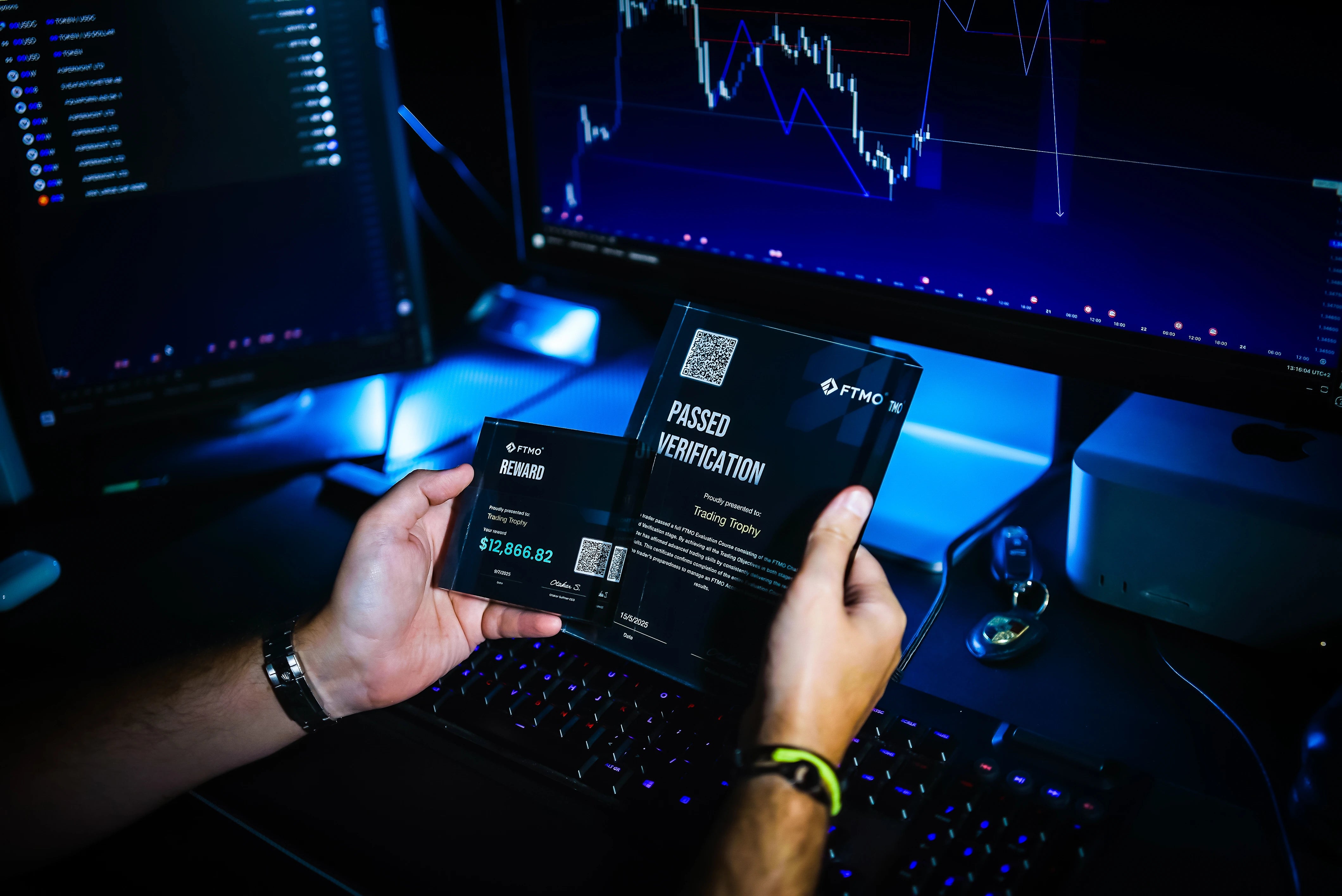 trader holds two trading trophies in his hands